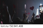Audience holding heart-shaped signs during a live concert performance with dramatic lighting effects. Стоковое видео, видеограф Данил Руденко / Фотобанк Лори