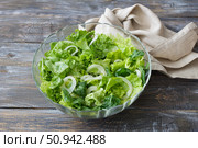 Fresh green lettuce and spinach salad in glass bowl on rustic wooden table, healthy organic food. Стоковое фото, фотограф Ольга Лепёшкина / Фотобанк Лори