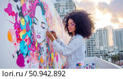 Creative Artist in Process: Painting a Colorful Mural of a Woman's Face on Rooftop Terrace with Urban Building. Стоковое AI-изображение, AI-художник Данила Большаков / Фотобанк Лори