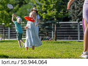Очаровательная девочка с мамой играет с фрисби. Редакционное фото, фотограф Андрей Иванов / Фотобанк Лори