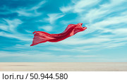 Conceptual freedom: A scarlet fabric dances mid-air against serene blue skies above arid land, evocative of boundless aspirations and dramatic flair. Стоковое AI-изображение, AI-художник Данила Большаков / Фотобанк Лори