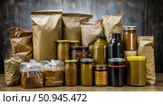 Pantry storage concept: Assortment of glass jars and paper bags filled with dry food in the home kitchen, zero waste lifestyle. Стоковое AI-изображение, AI-художник Данила Большаков / Фотобанк Лори