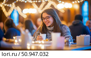 Festive Gathering Moment: smiling woman with eyeglasses enjoying a drink at an indoor event with bokeh lights, capturing a candid moment of joy and conviviality. Стоковое AI-изображение, AI-художник Данила Большаков / Фотобанк Лори