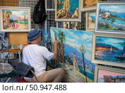Художник рисует и продает городские пейзажи в центре города Ялты, Республика Крым. Редакционное фото, фотограф Николай Винокуров / Фотобанк Лори