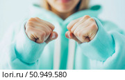 Close up Fists Empowerment Concept: A girl Wearing a Blue Sweater Showing Clenched Fists for Strength and Determination, Design for print, card, poster. Стоковое AI-изображение, AI-художник Данила Большаков / Фотобанк Лори