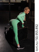 Young beautiful woman doing one-arm dumbbell back exercise on bench. Athletic blonde girl in the gym. Exercises for the latissimus dorsi. Стоковое фото, фотограф Михаил Решетников / Фотобанк Лори