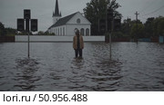 Devastating floodwaters surrounding lone figure and loudspeakers near church building, depicting climate change impact on vulnerable urban environment. Стоковое AI-видео, аниматор Данил Руденко / Фотобанк Лори