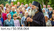 Elderly Russian Orthodox Priest Addresses Congregation Outdoors. Generative AI. Стоковое AI-изображение, AI-художник Roman Zavorotny / Фотобанк Лори