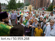 Священник кропит святой водой людей в престольный праздник в Серафимовском храме Балашихи, Редакционное фото, фотограф Дмитрий Неумоин / Фотобанк Лори