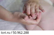 Slow-motion video of a ribbed juniper wood ball massaging an infant's right palm and fingers. Pediatric sensory stimulation therapy. Стоковое видео, видеограф Татьяна Степанищева / Фотобанк Лори