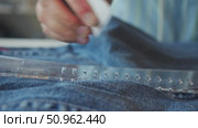 Piece of chalk employed by dressmaker to trace line on denim garments, which tailor can then use as reference for their work. Стоковое видео, видеограф Strunov David / Фотобанк Лори