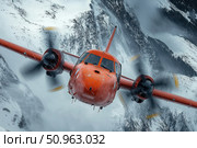 A red turboprop plane flies through a severe snowstorm over snow-capped mountain peaks. This dramatic image captures the dynamics, power and tension of a rescue or exploration mission. The close-up highlights the details of the fuselage, ice marks and spinning propellers, giving the shot a sense of movement and extreme action. Suitable for aviation, arctic expeditions, rescue, climate and adventure themes. Стоковое AI-изображение, AI-художник Анна Кривицкая / Фотобанк Лори