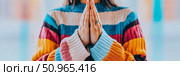 A peaceful moment of mindfulness with hands joined in a serene gesture, wearing a vibrant striped sweater, suitable for wellness and spiritual promotion. Стоковое AI-изображение, AI-художник Данила Большаков / Фотобанк Лори