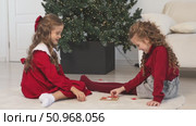 Little children girls play tic tac toe board game at home on the Christmas tree background. Children early development. Christmas and New Year holidays time. Board game and kids leisure concept. Стоковое видео, видеограф Ирина Михайличенко / Фотобанк Лори