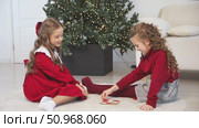 Little children girls play tic tac toe board game at home on the Christmas tree background. Children early development. Christmas and New Year holidays time. Board game and kids leisure concept. Стоковое видео, видеограф Ирина Михайличенко / Фотобанк Лори