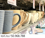 A row of white and blue cups on a shelf. Russia. Moscow. 02.08.25. Редакционное фото, фотограф Ярославский Максим / Фотобанк Лори