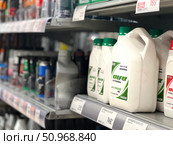 A row of white bottles of car care products are on a shelf. Russia. Moscow. 02.08.25. Редакционное фото, фотограф Ярославский Максим / Фотобанк Лори