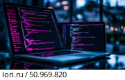 Dynamic close-up of two open laptops displaying vibrant lines of purple and blue programming code on their screens, set against a softly blurred dark background with warm bokeh lights, symbolizing modern software development and digital innovation. Стоковое AI-изображение, AI-художник Данила Большаков / Фотобанк Лори