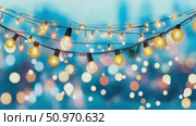 A charming string of glowing warm illuminations creating a festive ambiance against a shimmering blue and gold blurred backdrop. Стоковое AI-видео, аниматор Данила Большаков / Фотобанк Лори