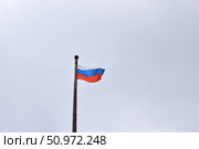 Флаг Российской Федерации на флагштоке, развевающийся на ветру, на фоне неба. Стоковое фото, фотограф Дмитрий Сакретарев / Фотобанк Лори
