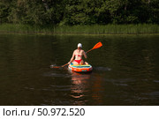Quaint Summer Afternoon Paddle Boarding on a Tranquil Lake With Lush Greenery Surrounding. Редакционное фото, фотограф Aleksandr Golubev / Фотобанк Лори