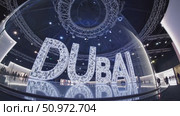 Large illuminated Dubai sign taking center stage in a spacious, modern exhibition hall, reflecting on the polished floor and capturing the essence of innovation and grandeur. Стоковое AI-видео, аниматор Данил Руденко / Фотобанк Лори