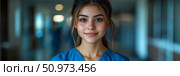 Compassionate and Professional: A smiling young female healthcare worker in blue scrubs confidently stands in a modern, softly lit medical environment. Стоковое AI-изображение, AI-художник Данила Большаков / Фотобанк Лори