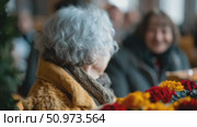 A gentle candid moment of an elder individual with silver hair, adorned in a cozy coat and scarf, surrounded by vibrant blurred blooms, with a cheerful countenance in the soft distance. Стоковое AI-видео, аниматор Данила Большаков / Фотобанк Лори