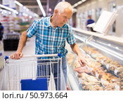 elderly retired senor asking seller for prepared food in cooking department of supermarket. Стоковое фото, фотограф Татьяна Яцевич / Фотобанк Лори