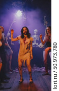 Electrifying Halloween celebration featuring a woman in zombie costume dancing amidst eerie smoke and haunting skeletal figures bathed in radiant violet light. Стоковое AI-видео, аниматор Данила Большаков / Фотобанк Лори