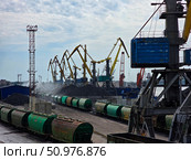 Краны в порту за работой по перевалке угля, погрузка и разгрузка грузовых вагонов в морском порту. Редакционное фото, фотограф Павел Авакумов / Фотобанк Лори