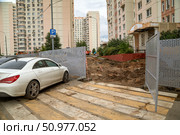 Производство земляных работ с нарушениями в непосредственной близости от жилого дома. Забор раскрыт, и с пешеходного перехода пешеход попадает прямо на строительную площадку. Москва, улица Большая Марфинская. Редакционное фото, фотограф Наталья Николаева / Фотобанк Лори