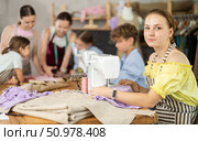 Teen girl stitching at machine during sewing class for children. Стоковое фото, фотограф Яков Филимонов / Фотобанк Лори