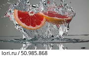 Grapefruit slice plummeting into water, generating dynamic liquid crown with splashing droplets against smooth gray surface, capturing vibrant citrus essence. Стоковое AI-видео, аниматор Данил Руденко / Фотобанк Лори