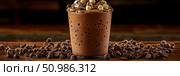 Decadent Chocolate Milkshake Delight: Creamy Drink Topped with Dark and White Chocolate Chips, Surrounded by Rich Scatter of Cocoa Morsels on Rustic Wooden Table. Стоковое AI-изображение, AI-художник Данила Большаков / Фотобанк Лори