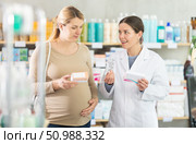 Pharmacist consulting pregnant woman on medication safety. Стоковое фото, фотограф Яков Филимонов / Фотобанк Лори
