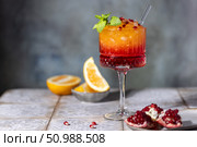 Sunrise cocktail in a tall glass with a straw, pomegranate, orange, crushed ice. Стоковое фото, фотограф Наталья Угрюмова / Фотобанк Лори