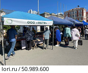 Люди покупают продукты на ярмарке "Приморские продукты питания" на площади Борцов Революции в 2023 году. Владивосток. Редакционное фото, фотограф Овчинникова Ирина / Фотобанк Лори