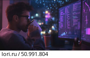 Tech enthusiast analyzes data trends at night in city apartment using dual monitors. Стоковое AI-видео, аниматор Сергей Толмачёв / Фотобанк Лори