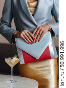 Businesswoman holding stylish silver and red clutch bag with red nails. Стоковое фото, фотограф Юрий Поздников / Фотобанк Лори