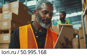 Warehouse worker assessing inventory in a busy distribution center during day shift. Стоковое AI-видео, аниматор Сергей Толмачёв / Фотобанк Лори