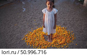 Barefoot woman wearing white dress meditating within circular arrangement of vibrant marigold flowers, surrounded by softly swirling incense smoke. Стоковое AI-видео, аниматор Данил Руденко / Фотобанк Лори
