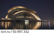 Dubai Opera gleaming on nighttime lake surface, surrounded by luminous city lights and dramatic architectural skyline, capturing metropolitan elegance. Стоковое AI-видео, аниматор Данил Руденко / Фотобанк Лори