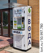 Outdoor water vending machine with purified drinking water near brick wall of convenience store. Редакционное фото, фотограф Сергей Пристяжнюк (Serg Zastavkin) / Фотобанк Лори