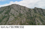 Scenic landscape featuring steep mountains and dense forests in a valley, with dramatic cloud formations above, highlighting the tranquility of the natural environment. Стоковое видео, видеограф Ирина Ручушкина / Фотобанк Лори