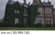 Verdant ivy ascending weathered stone walls of grand Victorian estate, enveloping historic architecture against moody gray sky. Стоковое AI-видео, аниматор Данил Руденко / Фотобанк Лори