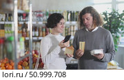Husband and wife scans QR code on cheese label in a grocery store. Стоковое видео, видеограф Яков Филимонов / Фотобанк Лори