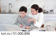 Boy studiyng using laptop, mother helping and explaining. Boy studiyng, mother helping. Стоковое видео, видеограф Яков Филимонов / Фотобанк Лори