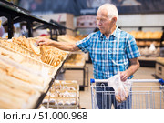 old age senor examines bakery products in the grocery section of the supermarket. Стоковое фото, фотограф Татьяна Яцевич / Фотобанк Лори