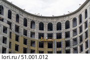 Installation of external wall thermal insulation with rock wool. Monolithic concrete frame of apartment building under construction with partially attached facade cladding blocks. Energy efficiency. Стоковое фото, фотограф Данила Большаков / Фотобанк Лори